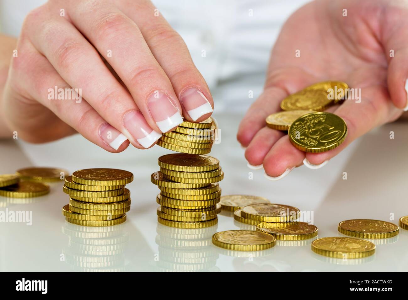 Woman with coin stack saving money Stock Photo - Alamy