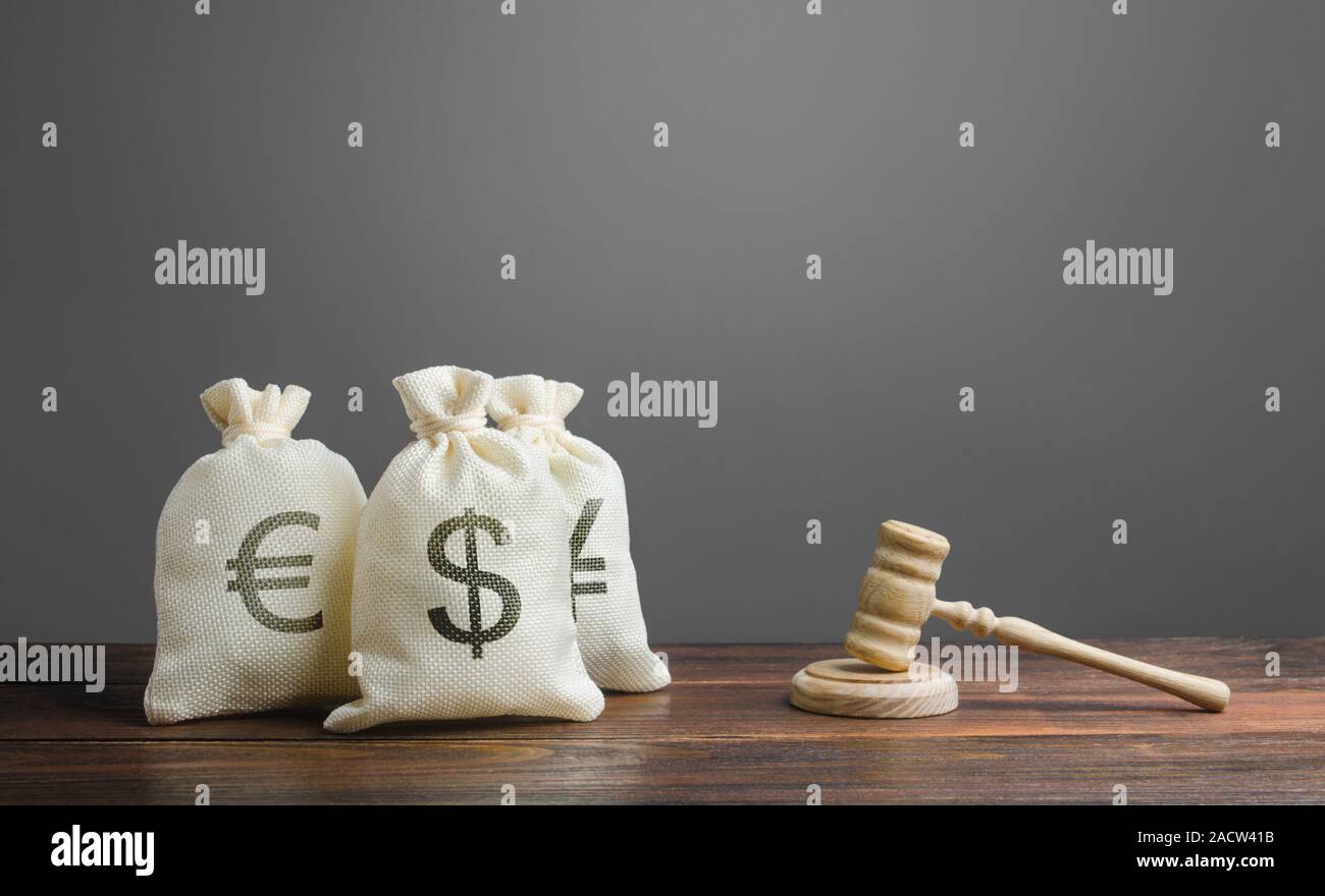 Bags of money and a judge's hammer. Litigation on financial matters. Legislation and rules, laws in the finance sector of economy. Investments and mov Stock Photo