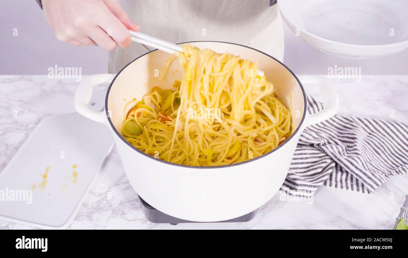 Step by step. Serving a onepot pasta into a white pasta plate Stock