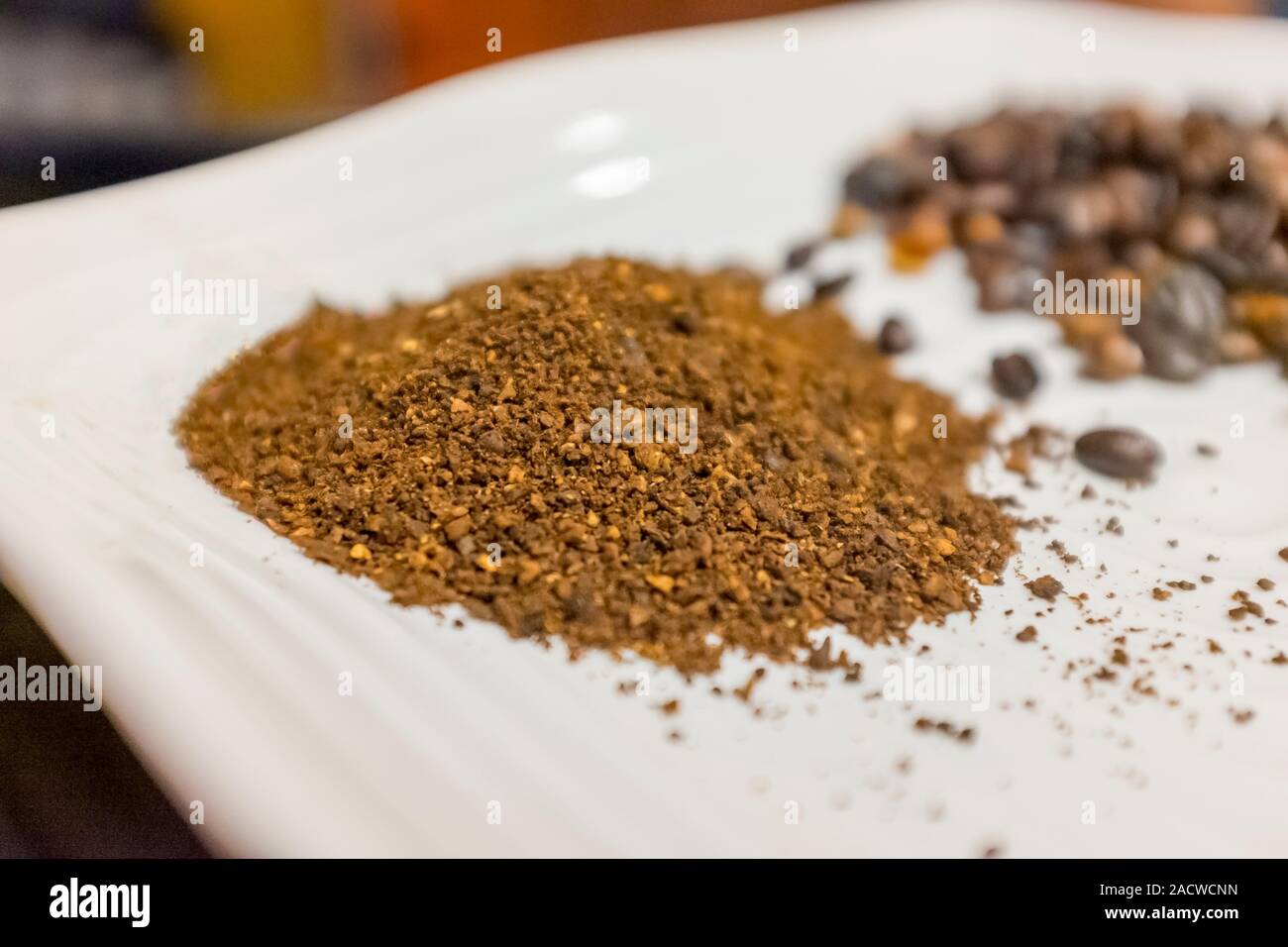 Ground Ethiopian coffee beans, with roasted whole beans in the