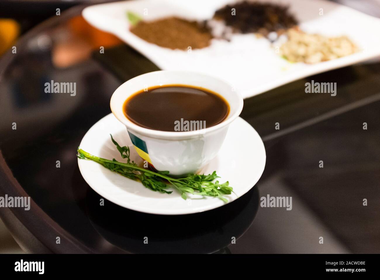 A cup of buna (Ethiopian coffee), served with Tena'adam leaves, in Addis Ababa, Ethiopia Stock Photo