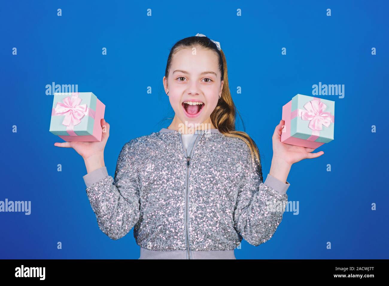 Girl with gift boxes blue background. Black friday. Shopping day. Cute child carry gift boxes. Surprise gift box. Birthday wish list. World of happiness. Pick bonus. Special happens every day. Stock Photo