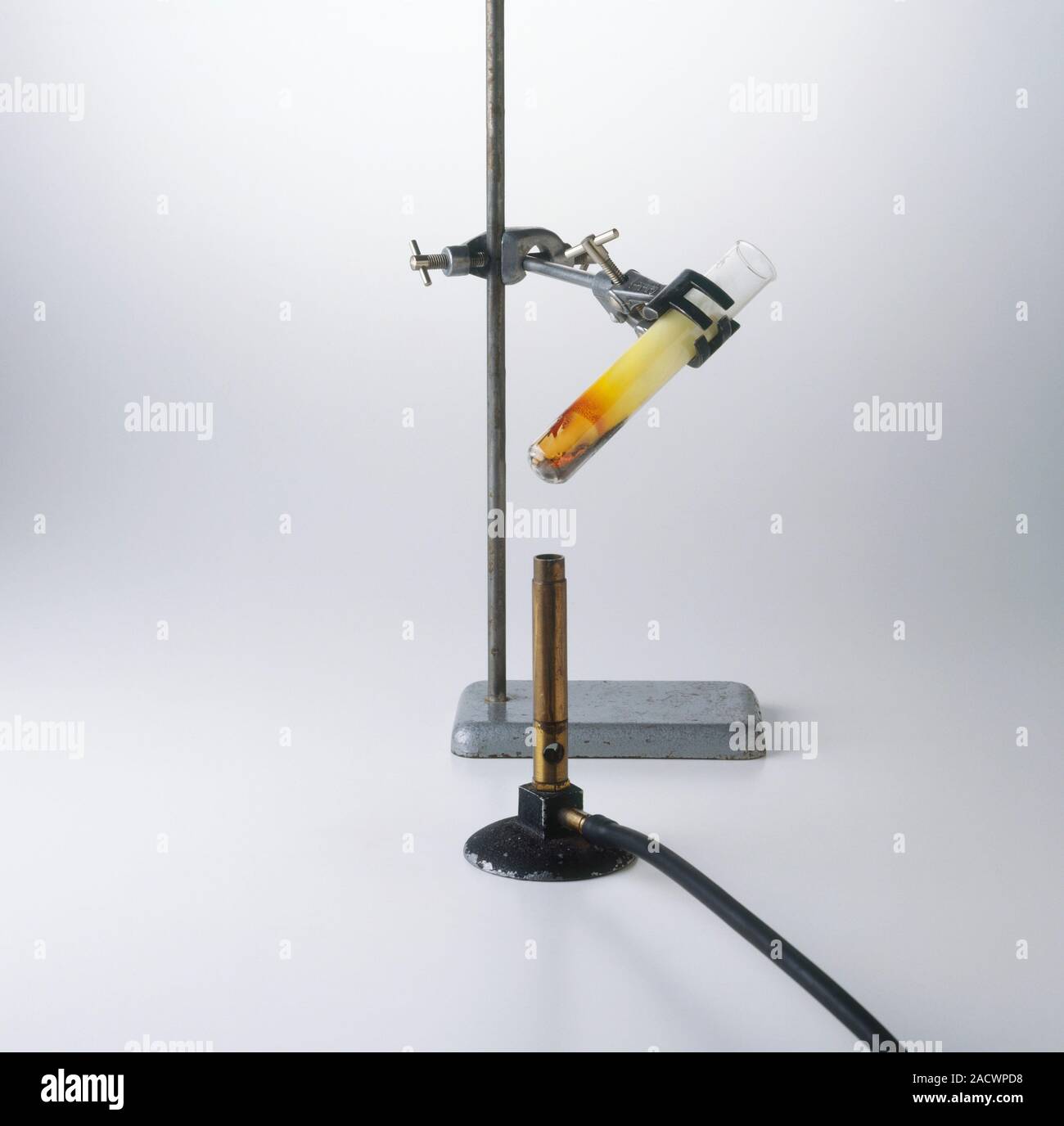 Test tube of sulphur and iron mix held in tongs above bunsen burner