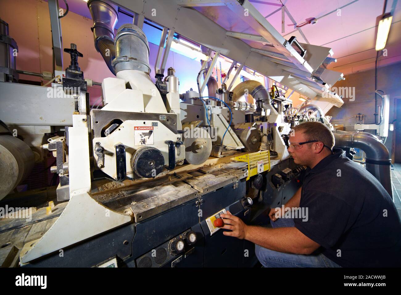 Manufacturing process of timber decking planks showing machine operator ...