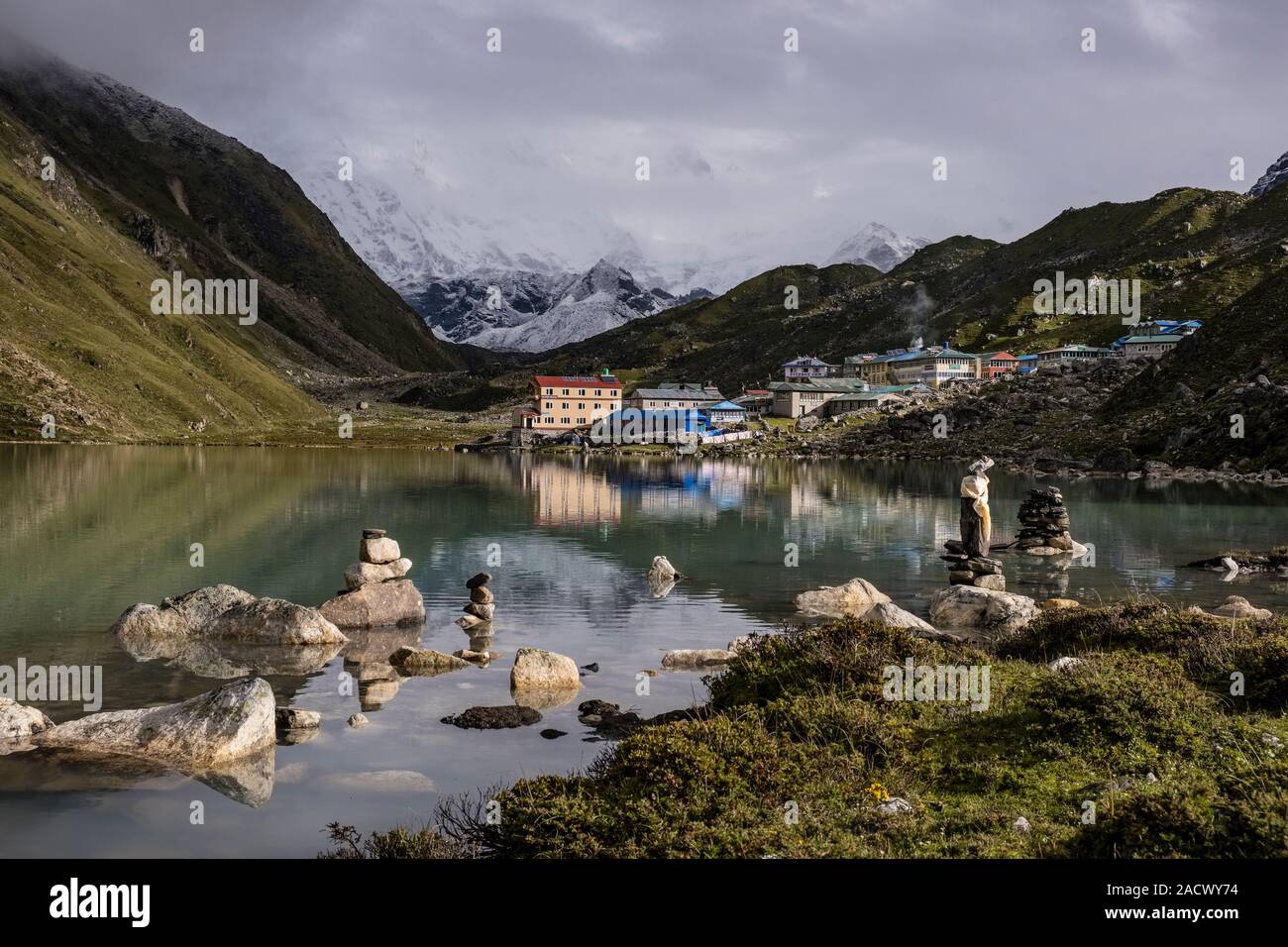 View of the village Gokyo, located at Gokyo Lake, mountainous landscape covered in monsoon clouds in the distance Stock Photo