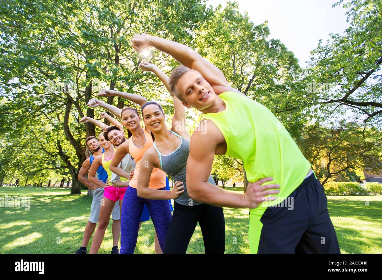 fitness, sport and healthy lifestyle concept - group of happy people exercising at summer park or boot camp Stock Photo
