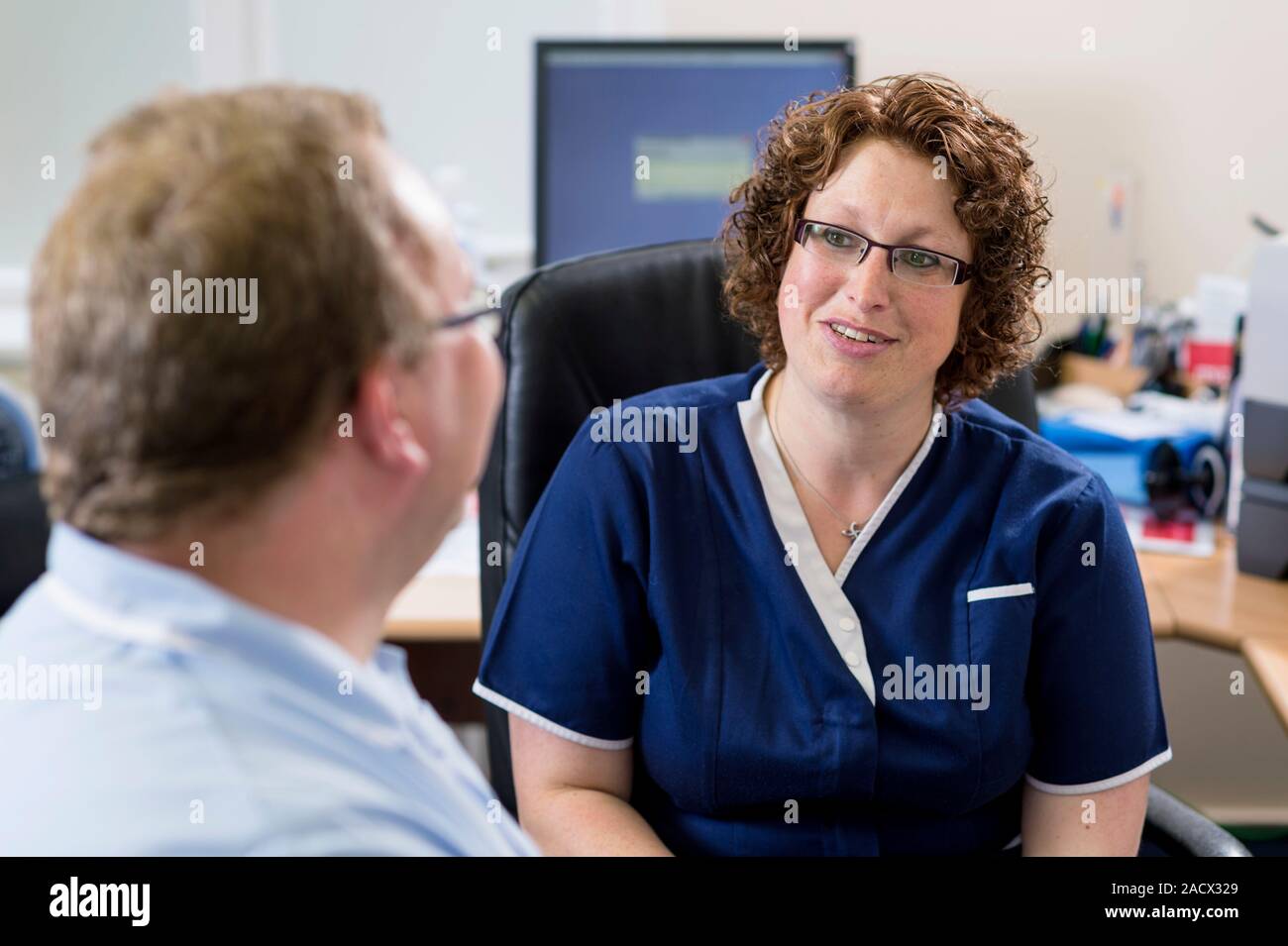 General practitioner (GP) and practice nurse having a meeting. Stock Photo