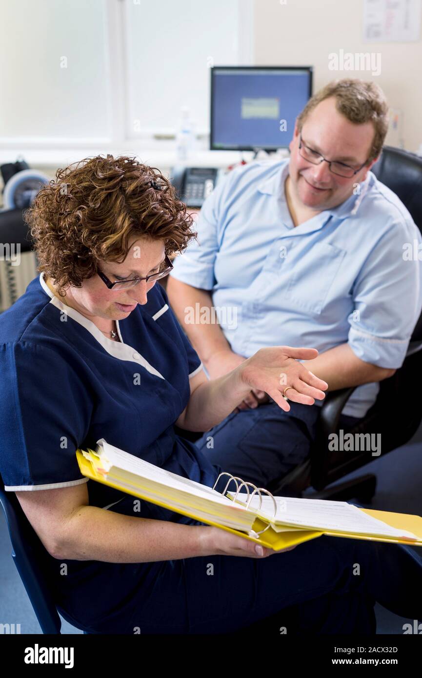 Doctor having a discussion with a practice nurse and going over some documents. Stock Photo