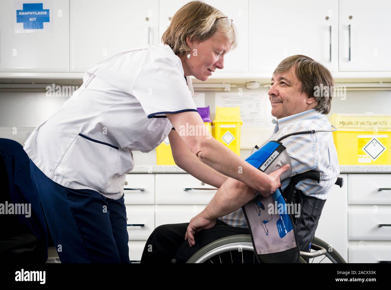 Practice nurse attaching the cuff of a sphygmomanometer to the arm of a