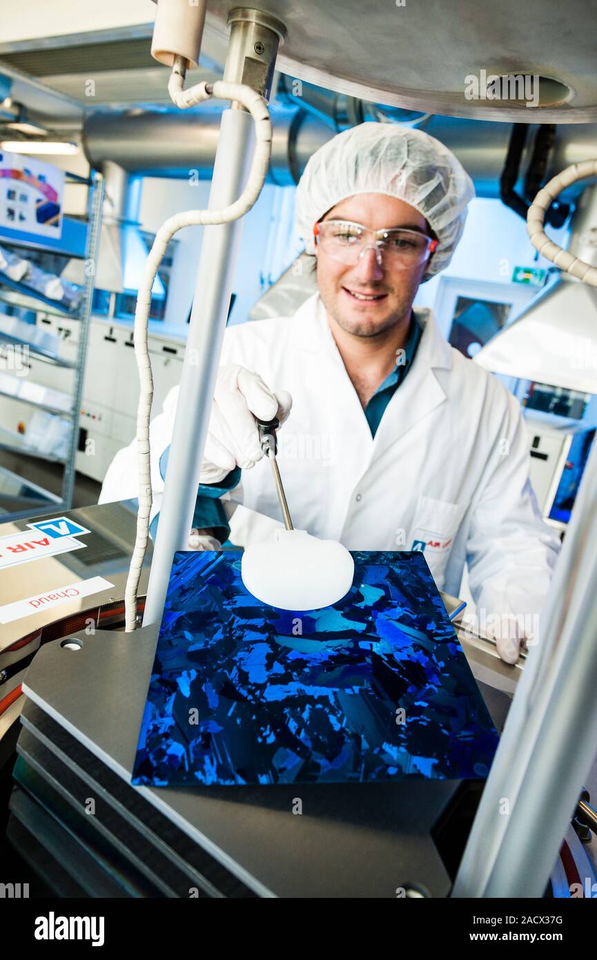 Photovoltaic cell research centre. Worker demonstrating the production of the combined crystalline silicon and anti-reflection layers used in photovol Stock Photo