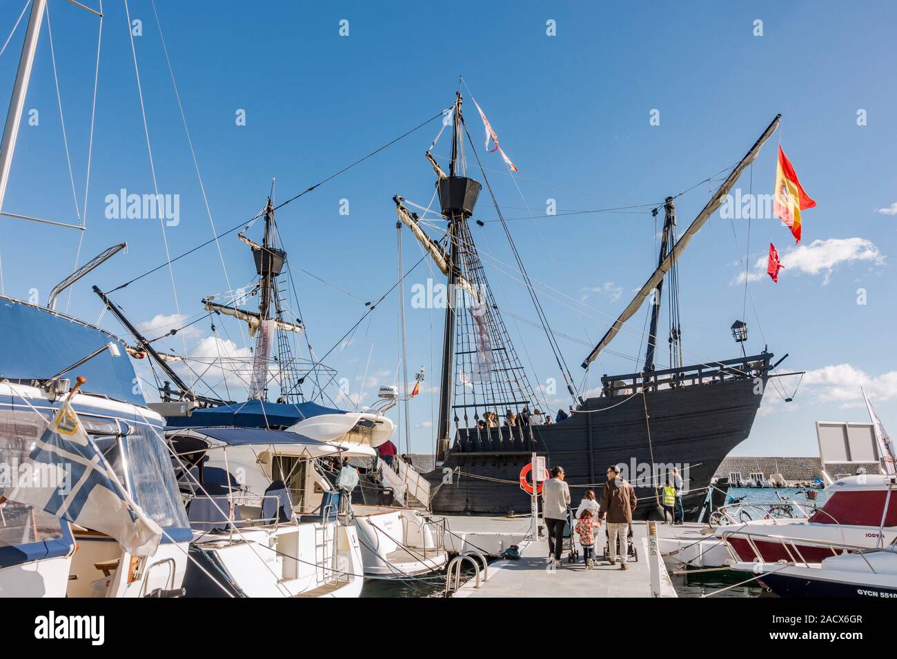 Family walks upon pier to Replica of old spanish galleon, Nao Victoria ...