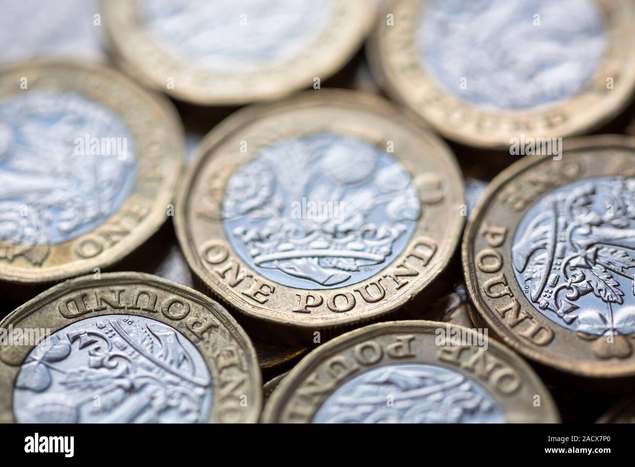 Close up of a pile of British Pound Coins with selective focus on the words 'One Pound' Stock Photo