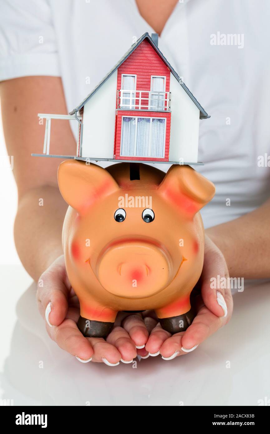 Woman with house and piggy bank Stock Photo - Alamy