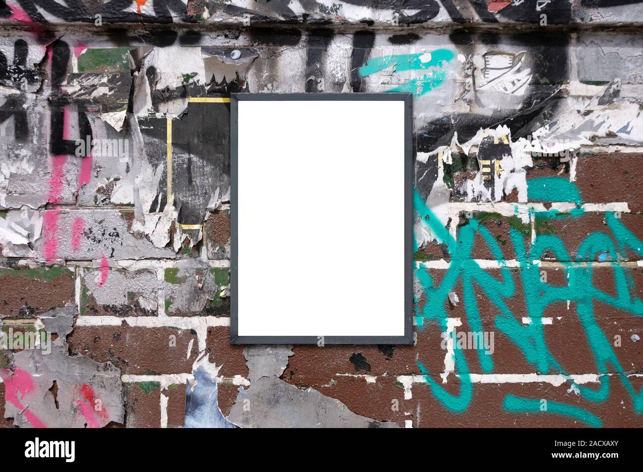 Blank notice advertising board for mockup on rough urban poster painted graffiti covered wall Stock Photo