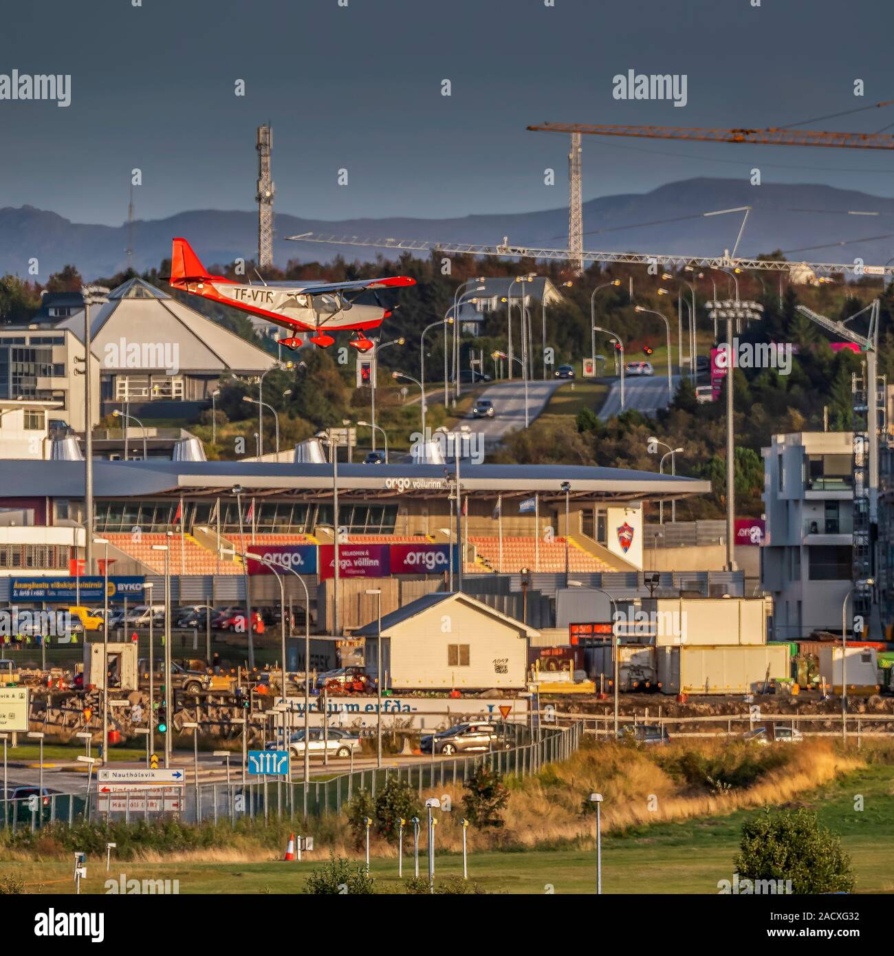 Small airplane flying, football stadium and buildings in the background, Reykajvik, Iceland Stock Photo