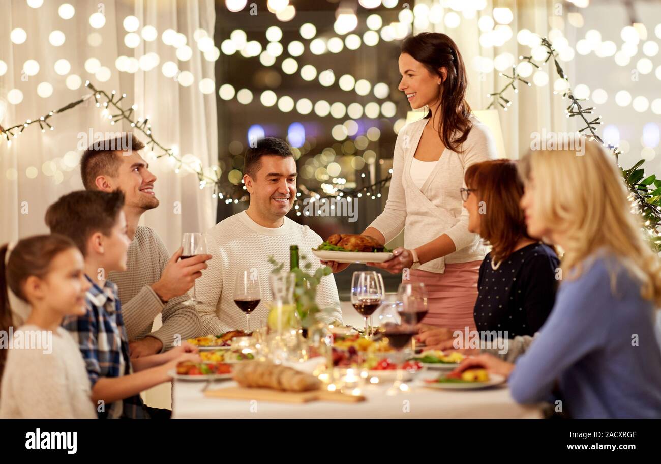 Celebration Holidays And People Concept Happy Woman Offering Roast Chicken To Family Having Dinner Party At Home Stock Photo Alamy