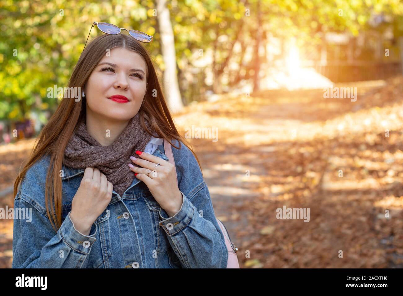 A young woman walks in the park. Autumn weekend in the city. Travel to the nature. Stock Photo