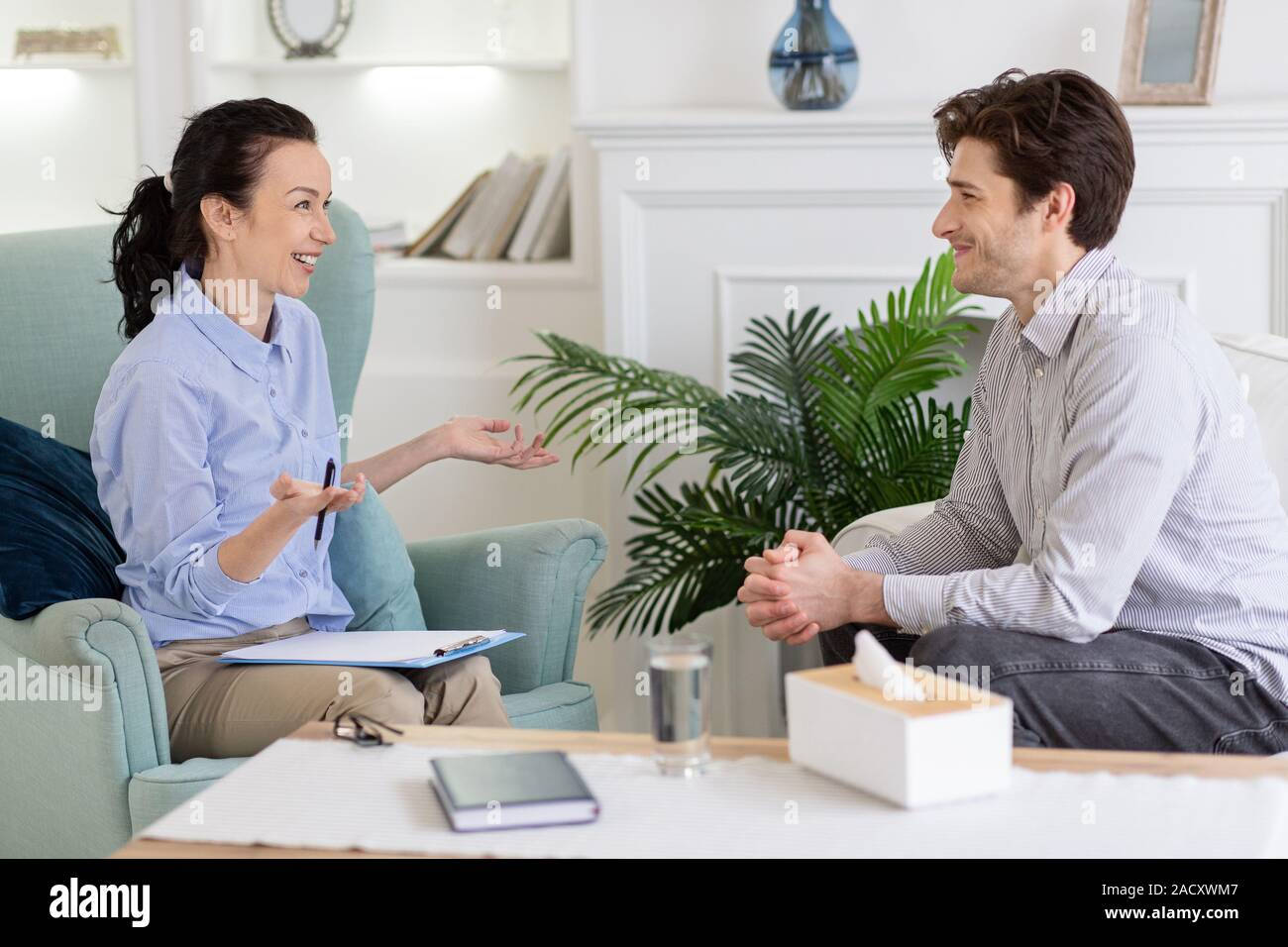 Relieved guy having pleasant conversation with psychologist Stock Photo