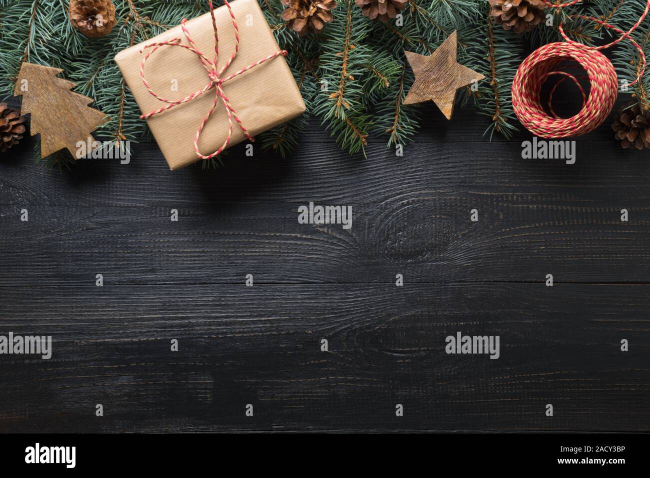 Christmas frame of fir branches, gift and wooden toys on dark wooden ...