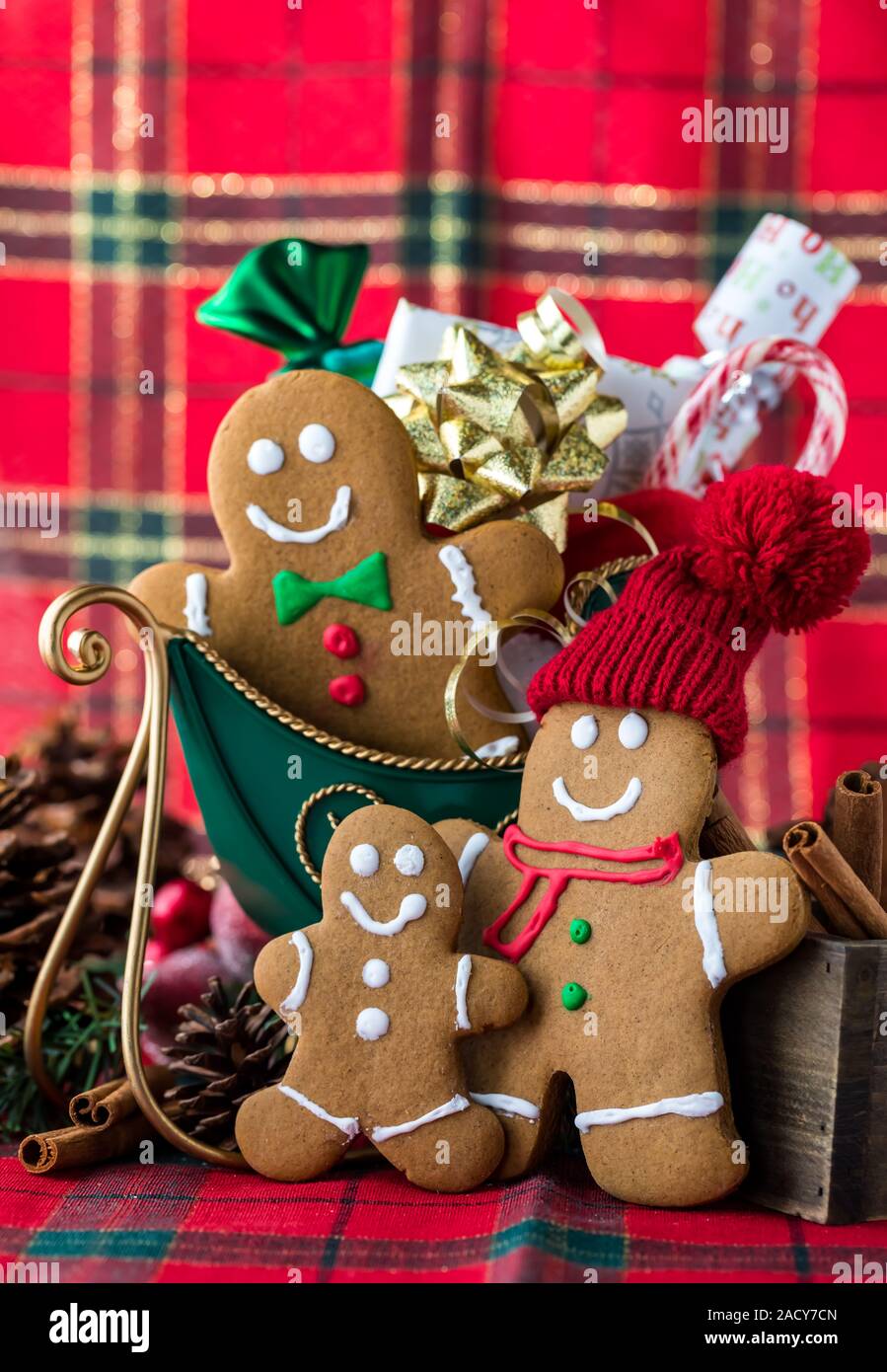 A close up view of a gingerbread family around a sled filled with presents to deliver on