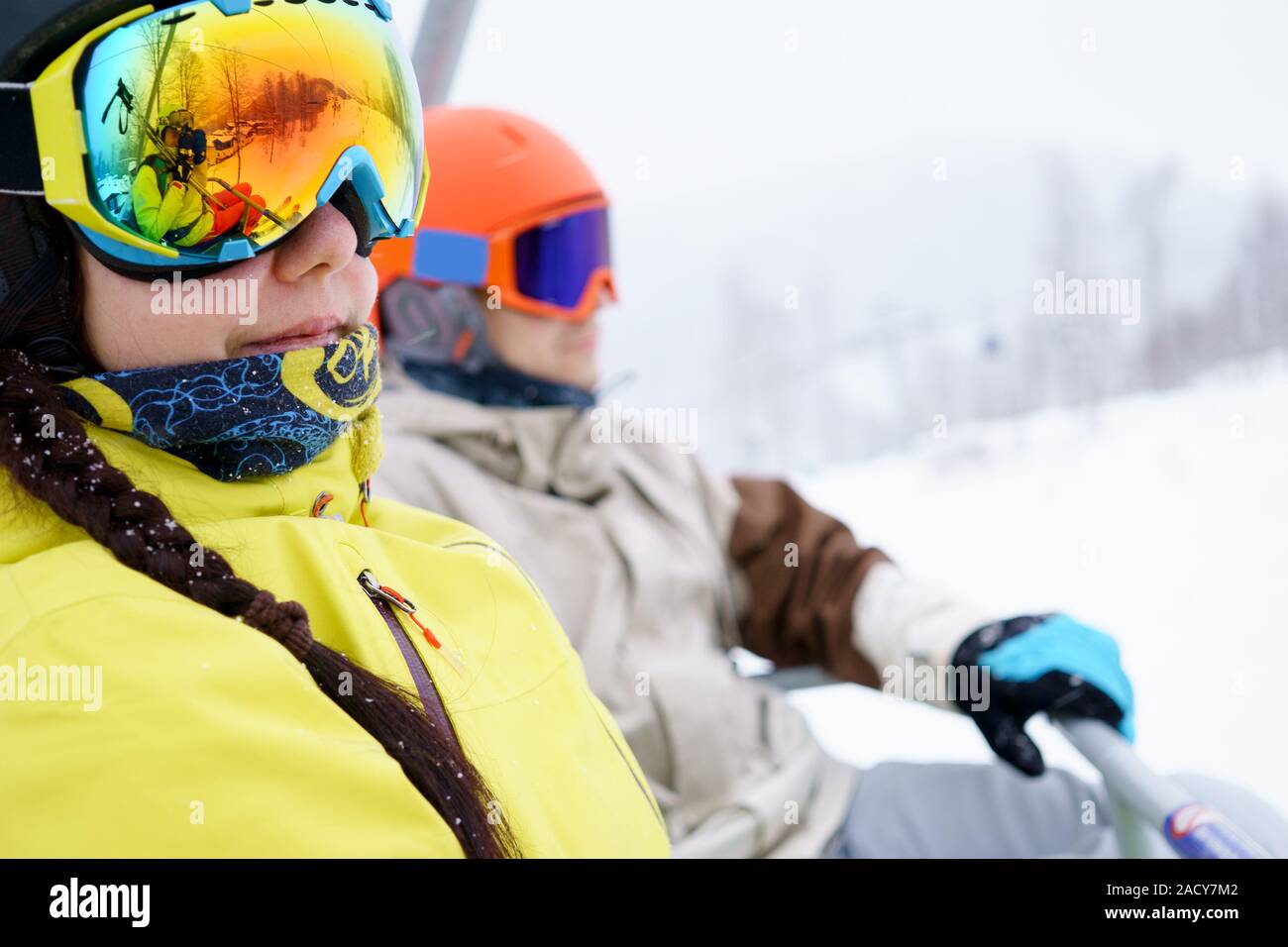 Couple sitting on chairlift in mountain resorts. Stock Photo