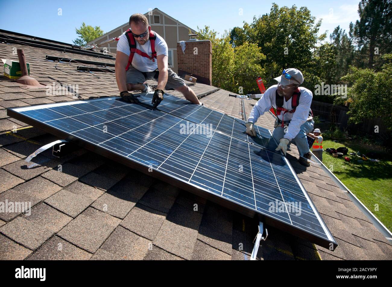 Domestic solar panel installation. Workers installing a domestic solar ...