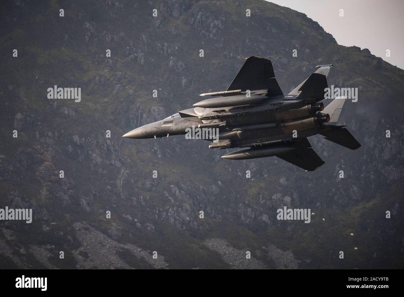F-15 Eagle, USAF Mc Donnell Douglas low-level fighter jet flying from Valley Anglesey through the Mach Loop in Cadair Idris Wales Stock Photo