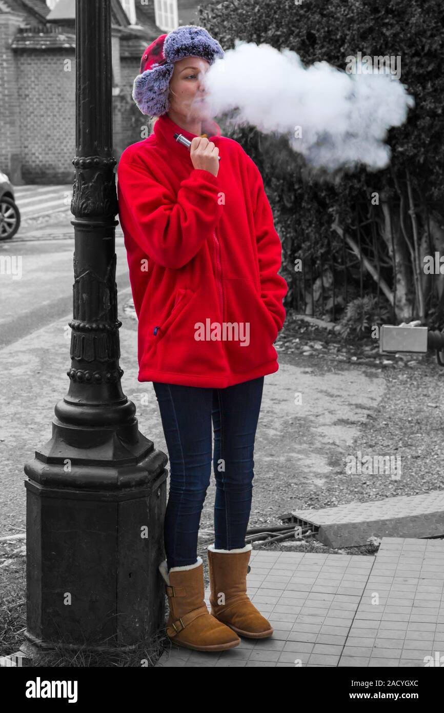 Woman vaping at Winchester, Hampshire, UK in November - selective colour colouring, colour popping Stock Photo