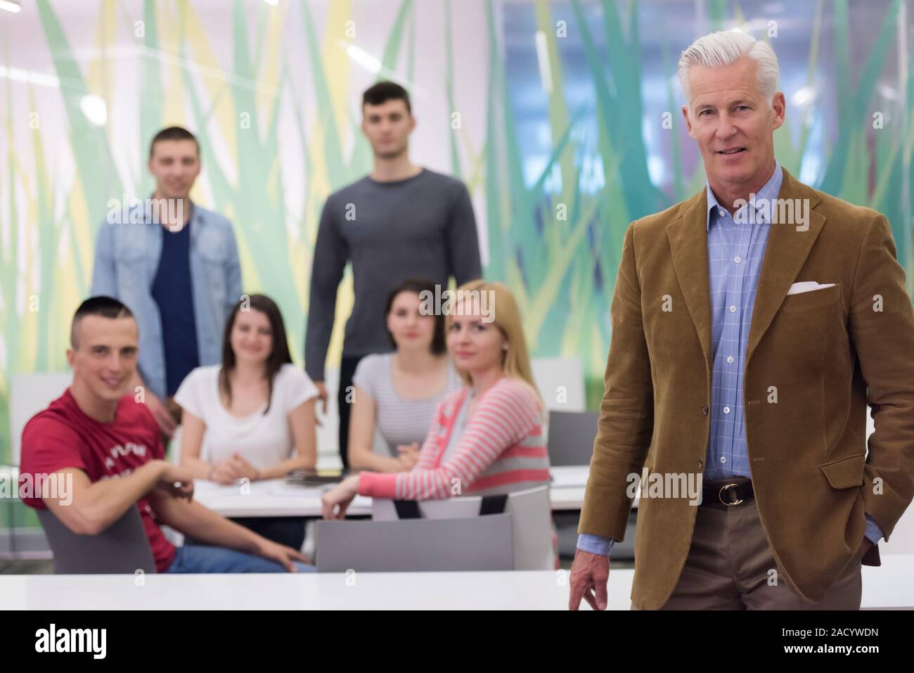 portrait of teacher with students group in background Stock Photo - Alamy