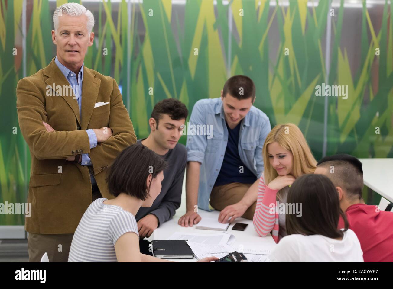 portrait of teacher with students group in background Stock Photo - Alamy