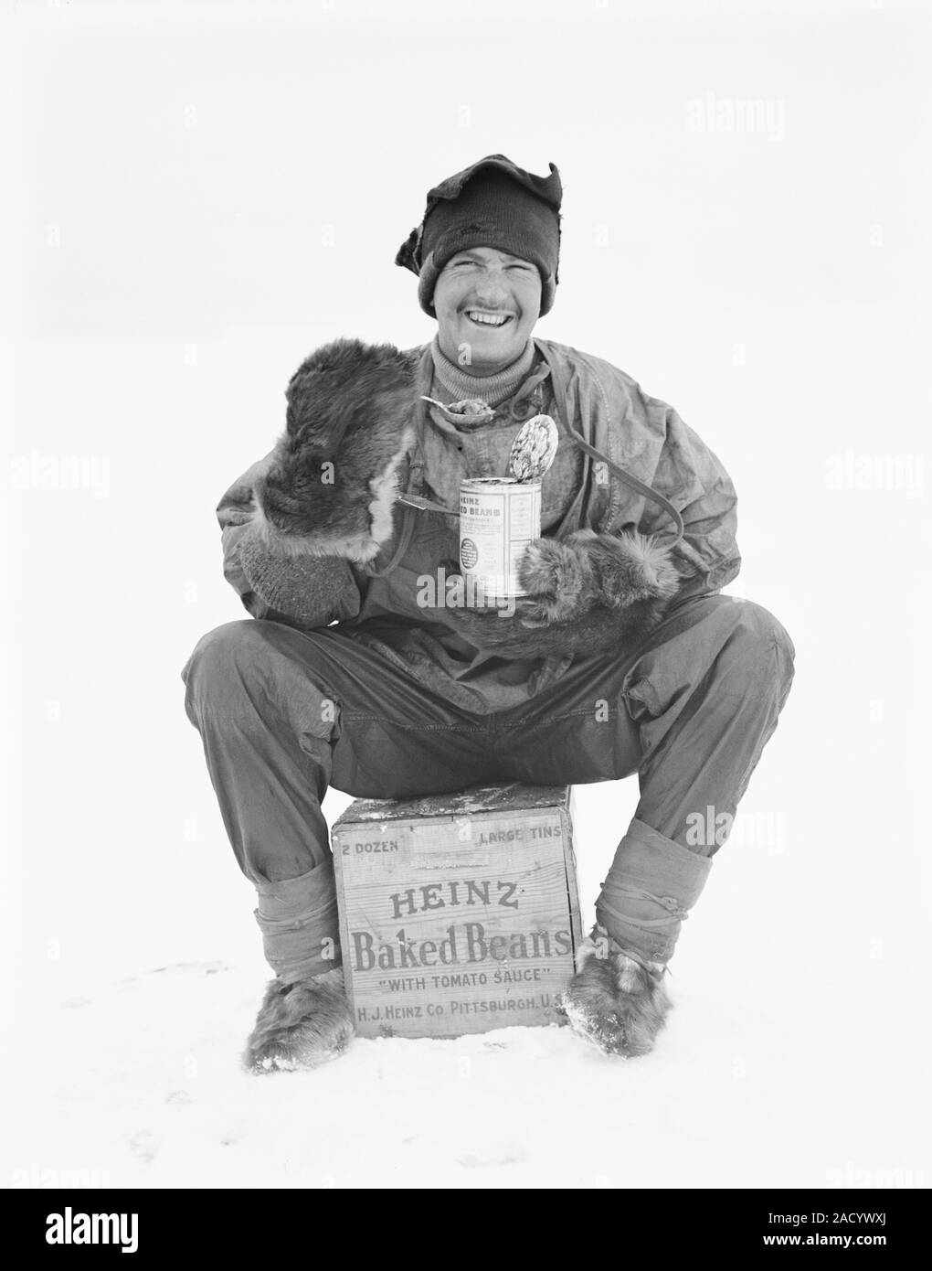Heinz baked beans in Antarctica. Antarctic explorer sitting on a crate