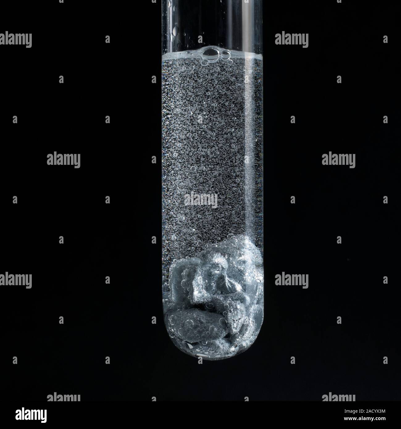 Zinc reacting with a strong acid. The reaction is vigorous, shown by