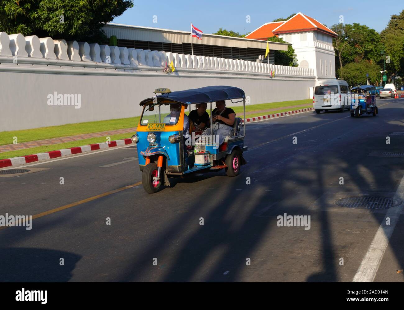 Bangkok, Thailand - December 2, 2019 : Closeup three wheels motor vehicle or tuk tuk running along the street between Wat Pho and Grand Palace wall Stock Photo