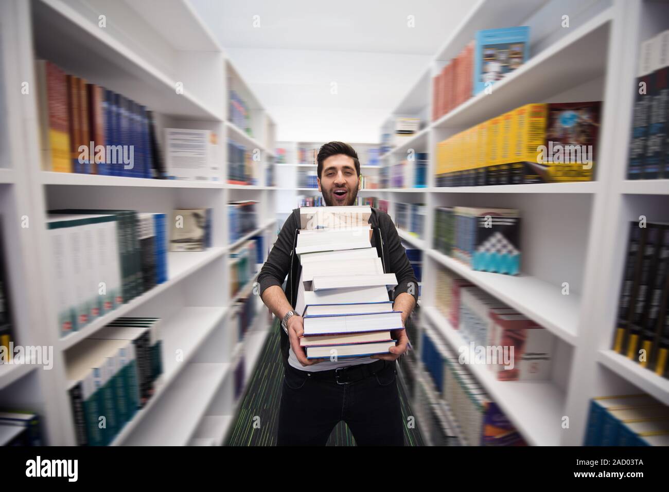 Student holding lot of books in school library Stock Photo - Alamy