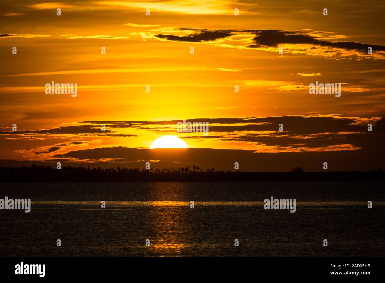 Spectacular golden sunset sky with illuminated clouds, coast of Zanzibar Stock Photo
