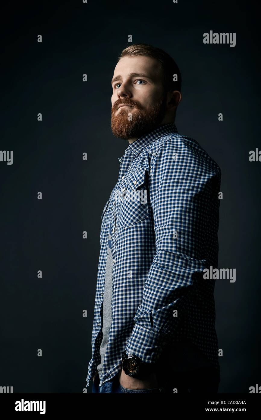 Pensive red bearded man studio portrait on dark background Stock Photo