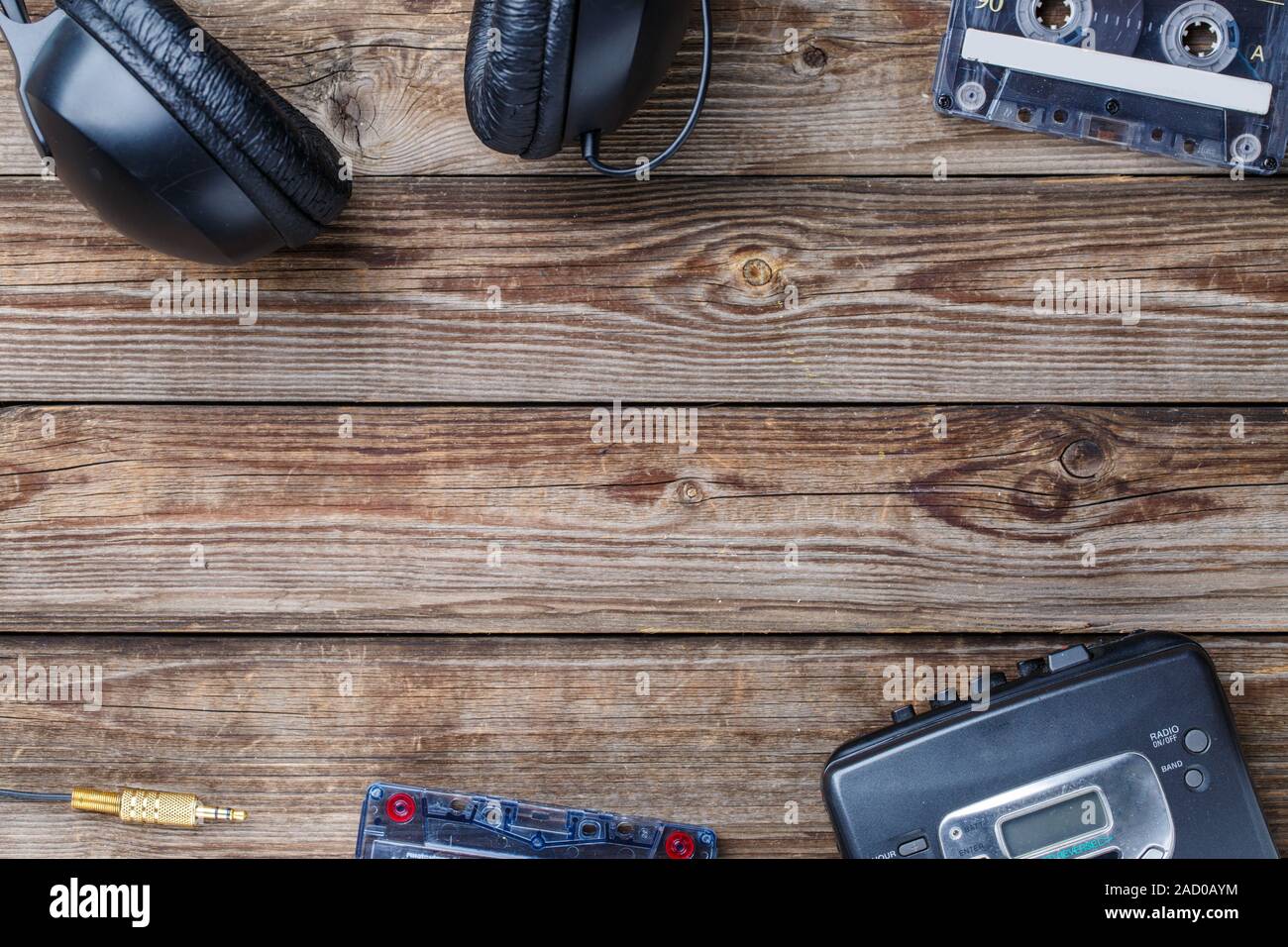 Cassette tapes, cassette player and headphones over wooden table. top view. Stock Photo