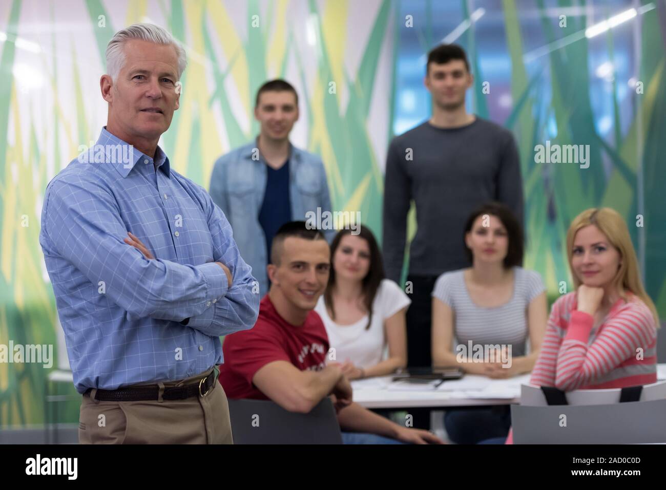 portrait of teacher with students group in background Stock Photo - Alamy