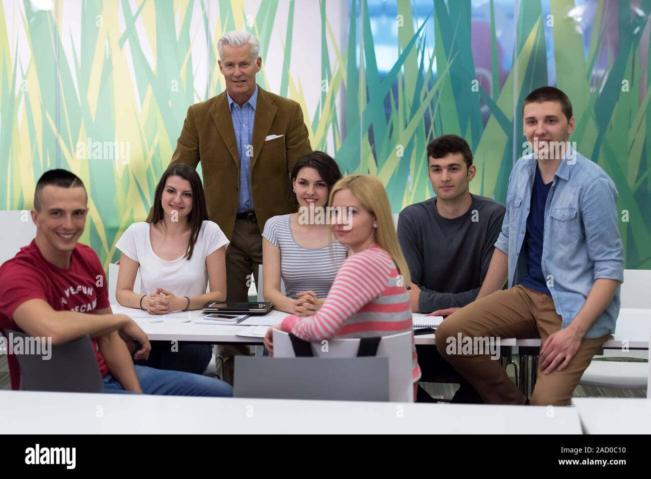 portrait of teacher with students group in background Stock Photo - Alamy