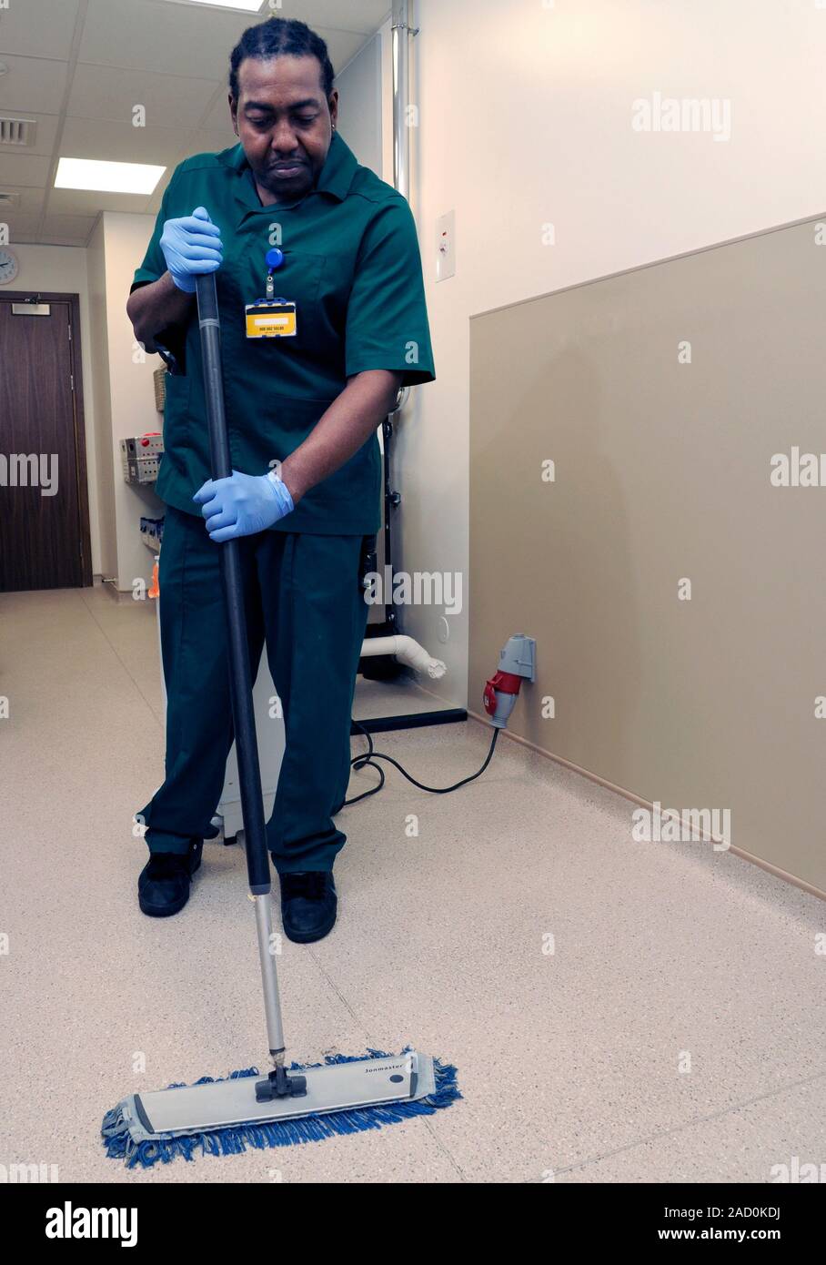 Hospital cleaner using a floor mop. Photographed in the UK Stock Photo
