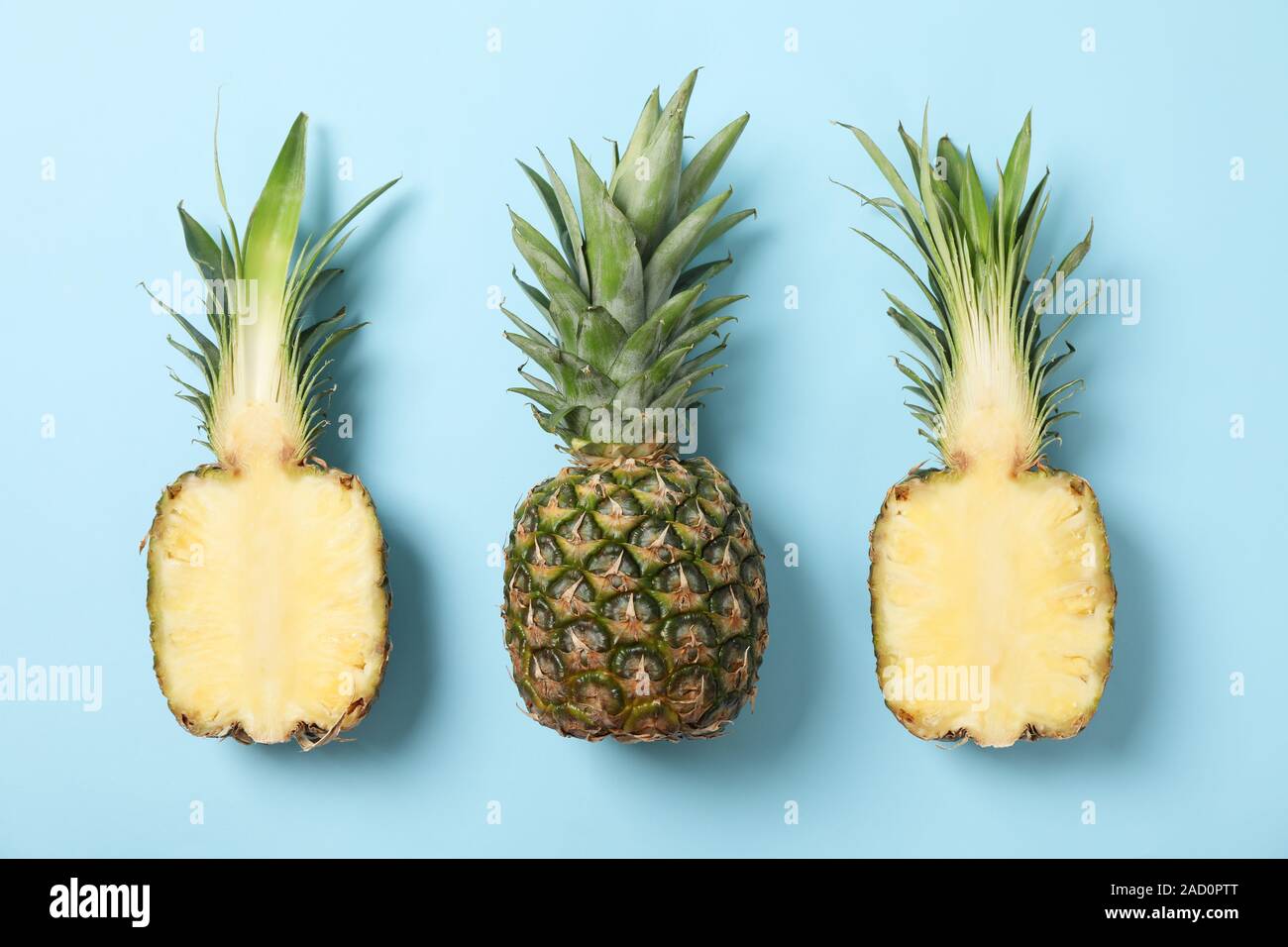 Pineapples on blue background, space for text. Juicy fruit Stock Photo