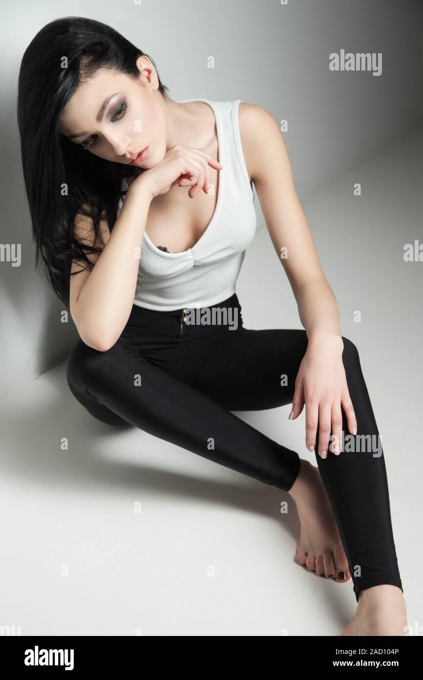dark-haired model on floor in studio Stock Photo