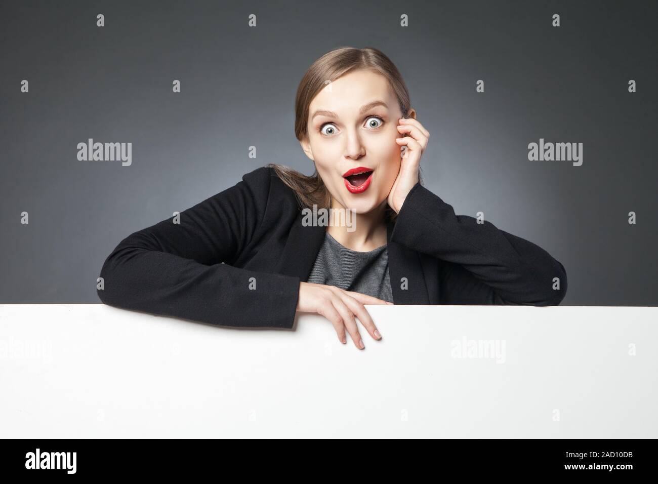 Wide-eyed woman with red lips looking at camera Stock Photo