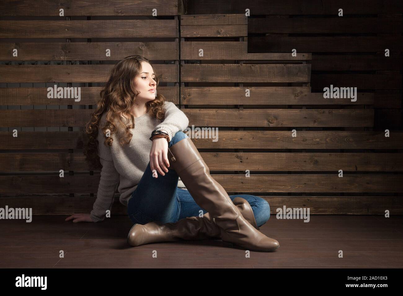 Young long-haired brunette on floor looking away Stock Photo