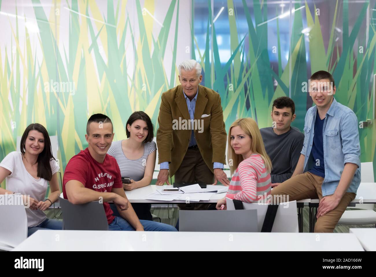 portrait of teacher with students group in background Stock Photo - Alamy