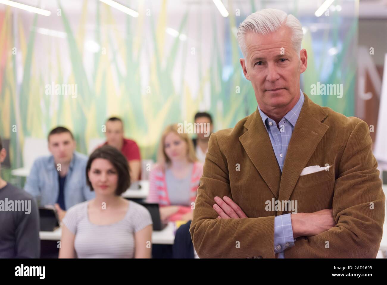 portrait of teacher with students group in background Stock Photo - Alamy