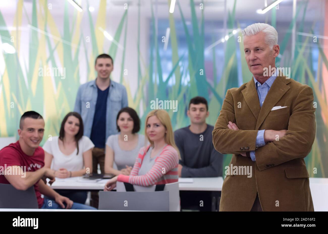 portrait of teacher with students group in background Stock Photo - Alamy