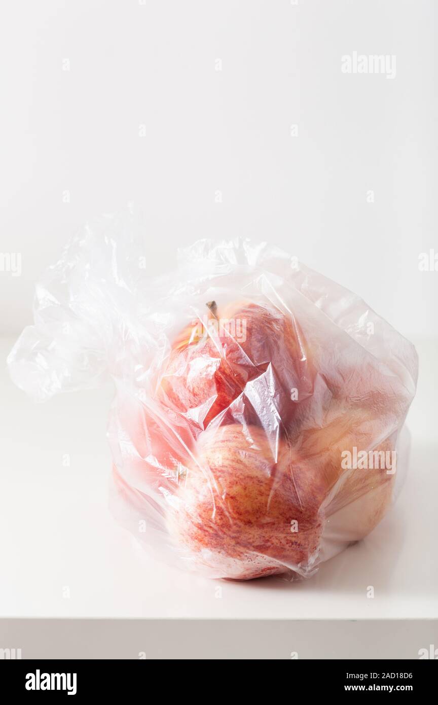 single use plastic packaging issue. apples in plastic bag Stock Photo
