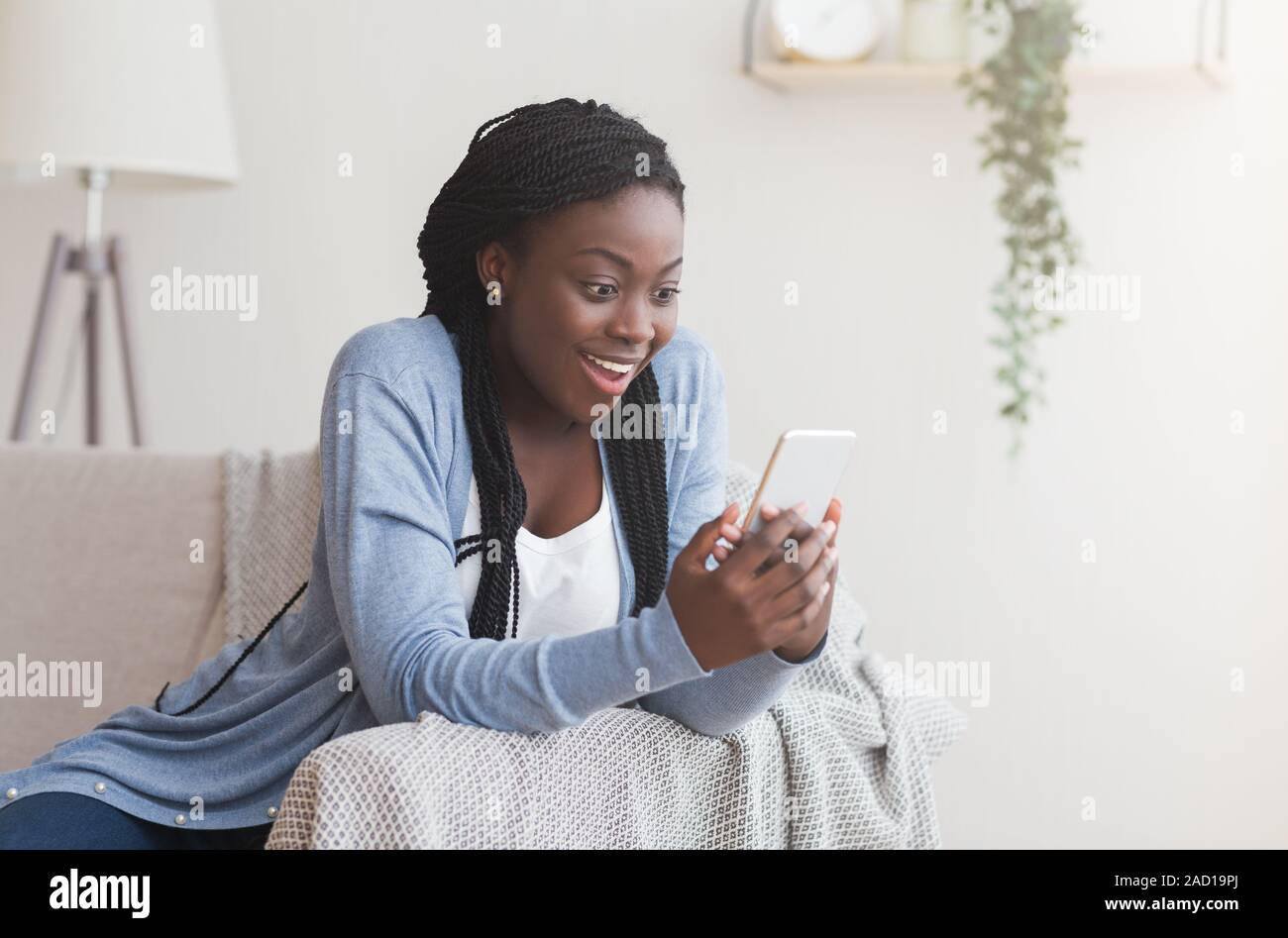Excited black woman receiving good news online in smartphone Stock ...
