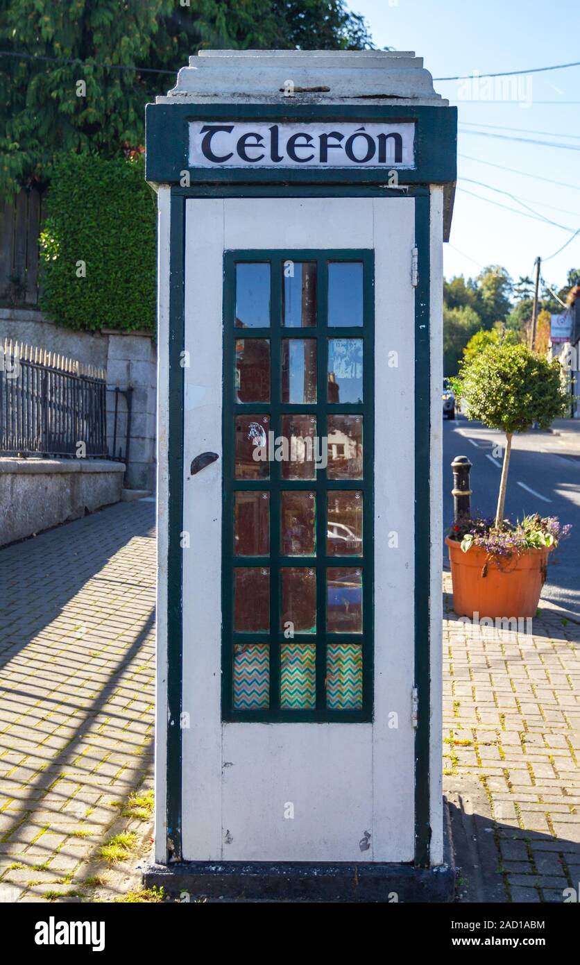 Vintage telephone kiosk, phone box, in Enniskerry village. Old fashioned dial payphone inside. Irish word Telefon on box. Wicklow, Ireland, Europe Stock Photo